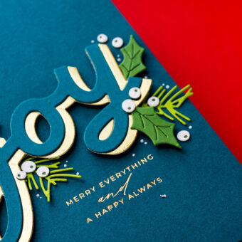 Another creative use was framing a sentiment with multiple “Joy” die-cuts in the corners — a completely different layout that draws the eye to the message at the center. (Side note: you may spot a missing “E” in my example — that was a prototype! Your finished dies will have everything you need.)